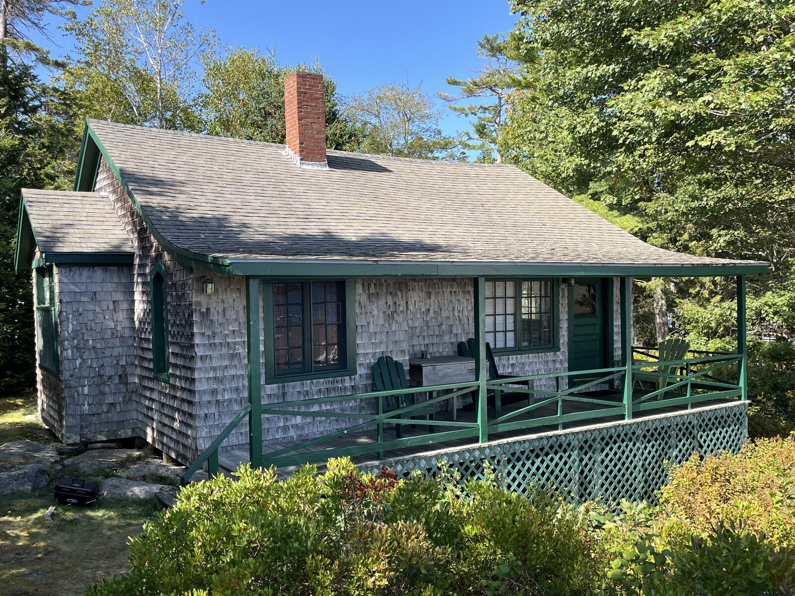 Hillside Cottage, a shingled cottage with green trim, tucked among pine trees at Gray Homestead