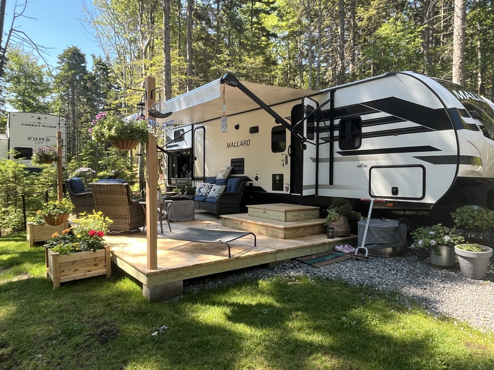 Site FR3, a wooded RV site with a deck and outdoor living area at Gray Homestead Oceanfront Camping