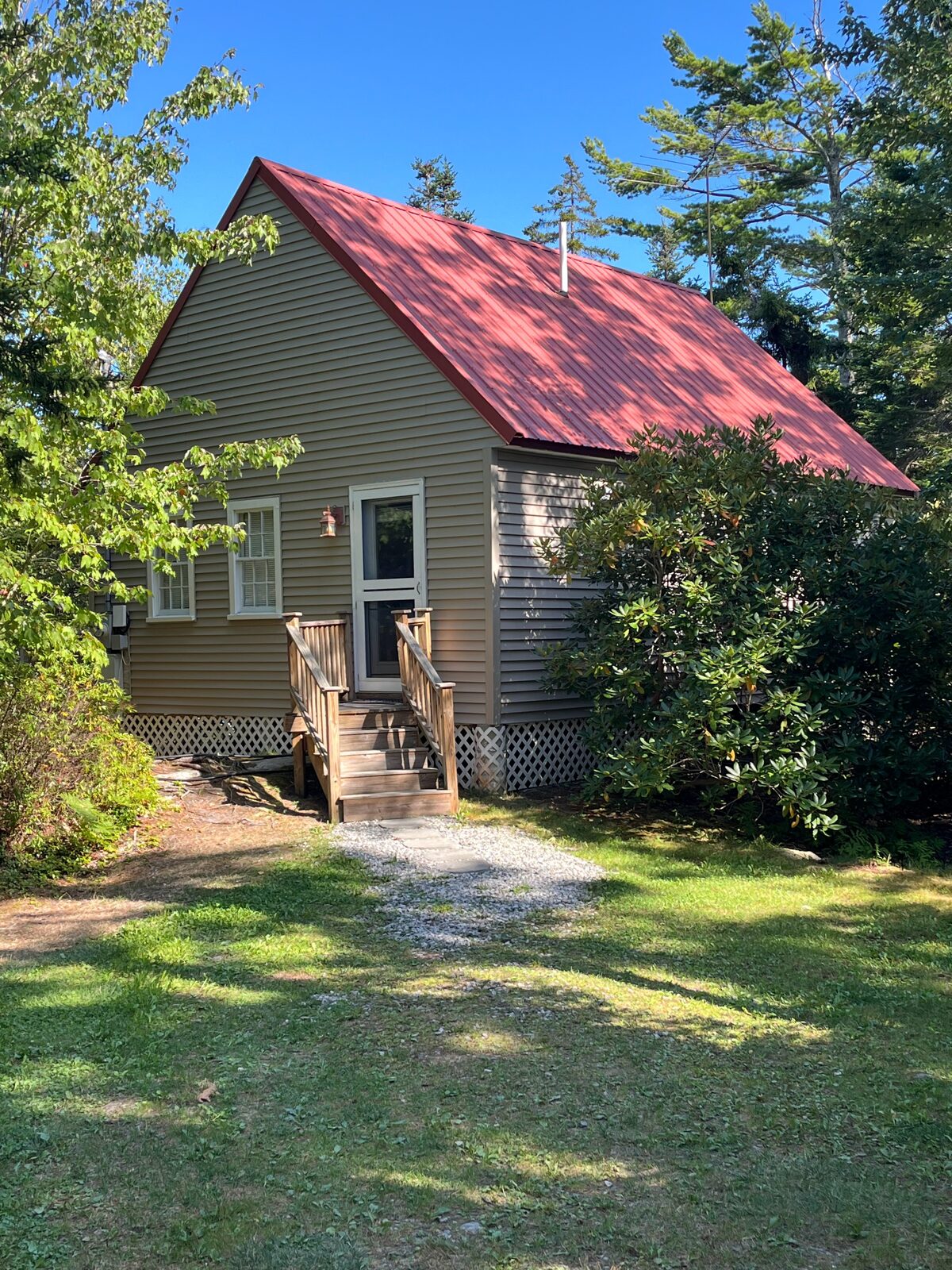 Outer Heron Cottage, a tan cottage with a red metal roof at Gray Homestead